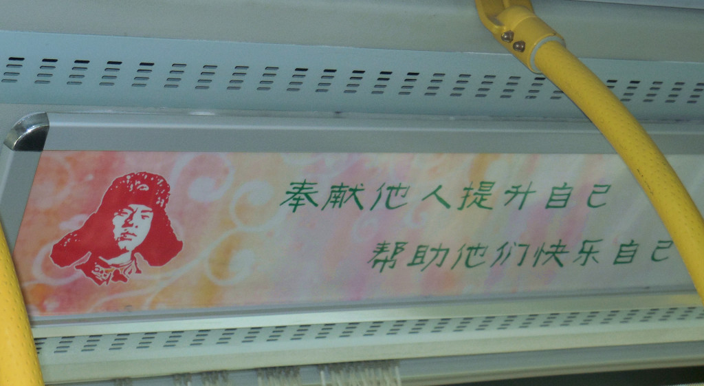 A poster with Lei Feng's portrait in a local bus in Xi'an says "To achieve self-growth by serving others; To gain happiness by helping others."