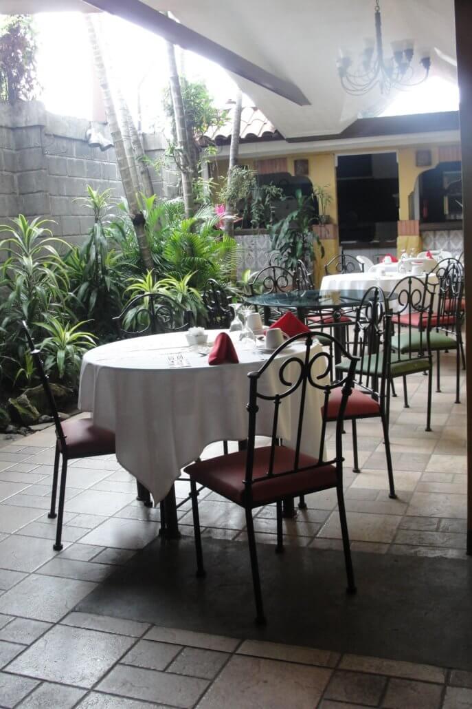 Outdoor dining area with plants at the Hotel 1915 in Alajuela,  Costa Rica