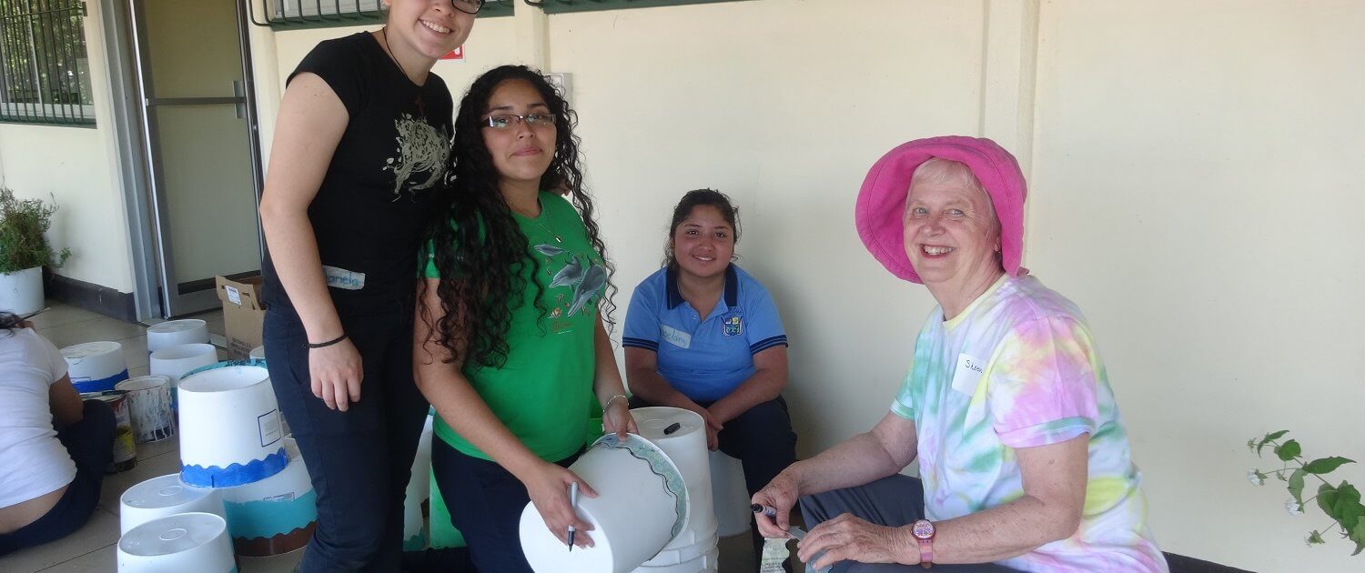 Global Volunteer Sharon painting buckets with students in Costa Rica