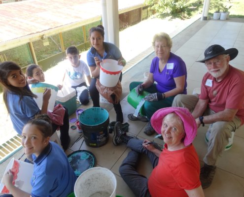 Costa Rica volunteers and students painting ice cream buckets together in Santa Elena, Monteverde