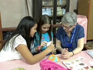 Mary working with two students on conversational English