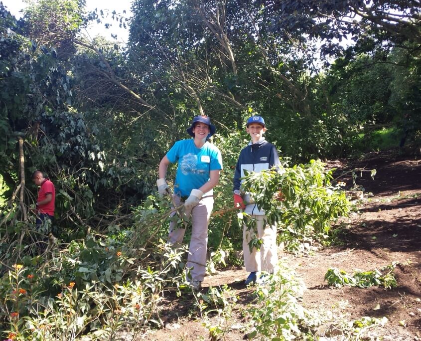 COS1508A1 - Julie Costa and Ben Fredricks clearing brush from butterfly garden with students 2