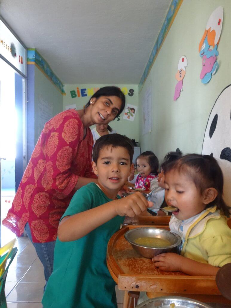 Sapna and Shaan Daly feeding babies in Ecuador.