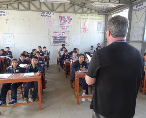 A volunteer in Peru teaches English to 6th graders