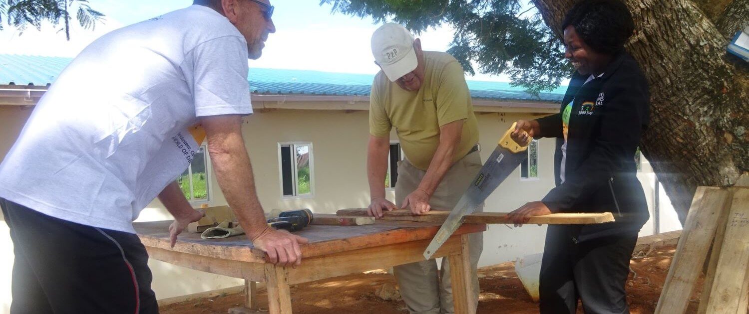volunteer abroad cutting-the-lumbers-for-the-greenhouse-tables-in-Tanzania