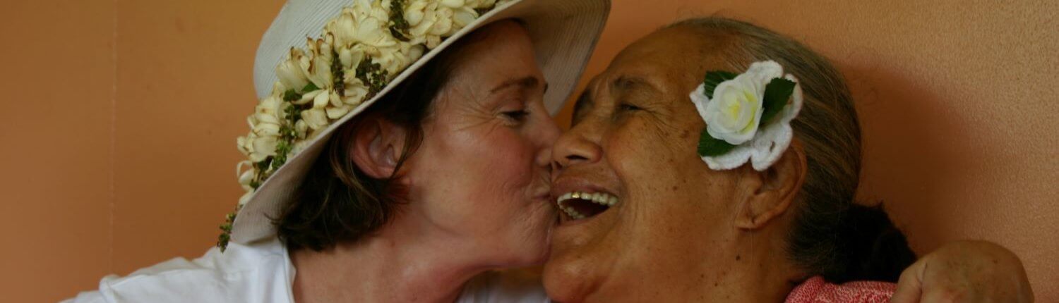 Volunteer abroad gives local woman a kiss in the Cook Islands