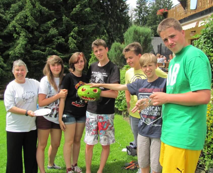 Volunteer carves watermelon with students poland