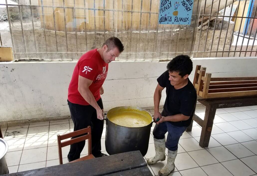 international Volunteer gives a hand to the Sagrada Familia staff to help them feed the children lima peru