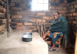 a mother from Tanzania cooks on a fuel-efficient stove built by Global Volunteers.