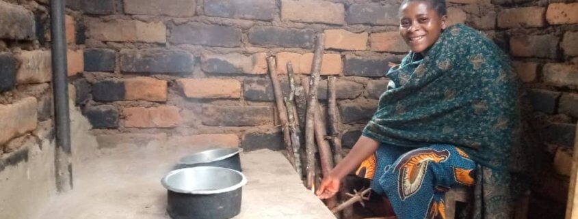 a mother from Tanzania cooks on a fuel-efficient stove built by Global Volunteers.