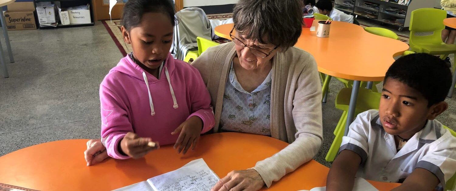 Volunteer Sonja Knudsen tutors students in English at the Apii Nikao school in The Cooks Islands.