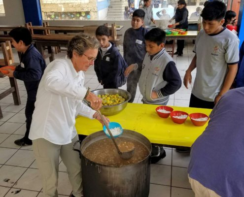 Volunteers help fill bowls with rice and lentils peru