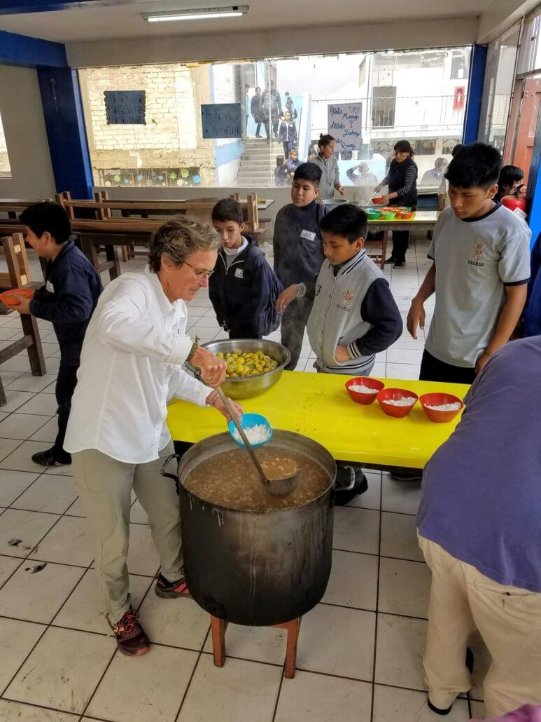 Volunteers help fill bowls with rice and lentils peru