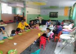Volunteers Hugh & Sandy Neville feed toddlers at the Day Care center in the Sagrada Familia children's home in Peru.