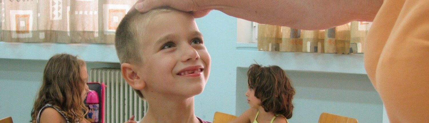 child is happy being praised by volunteer in Greece