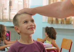 child is happy being praised by volunteer in Greece