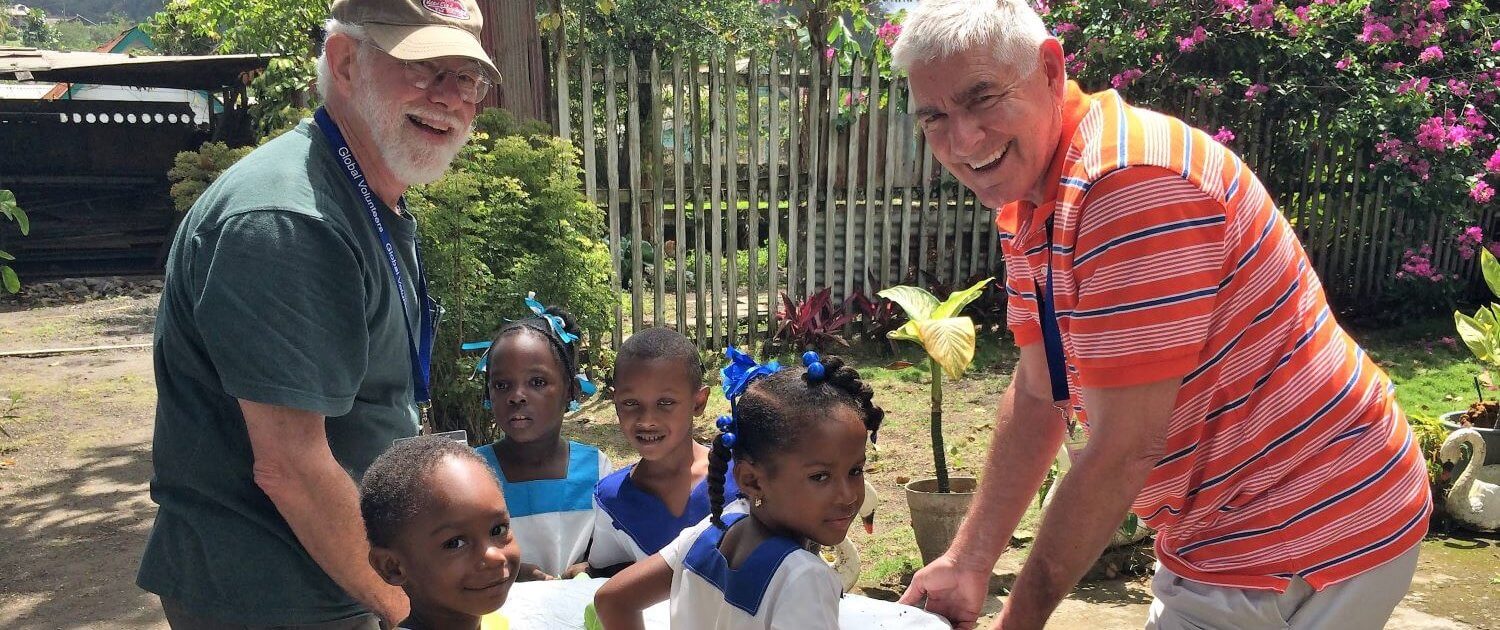 Volunteers Bill Chase & Henry Zeune working with children on school gardens in St. Lucia.
