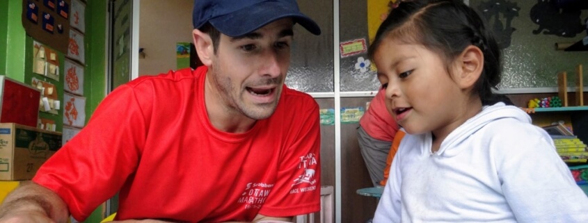 Volunteer reading with child stimulating brain in Ecuador