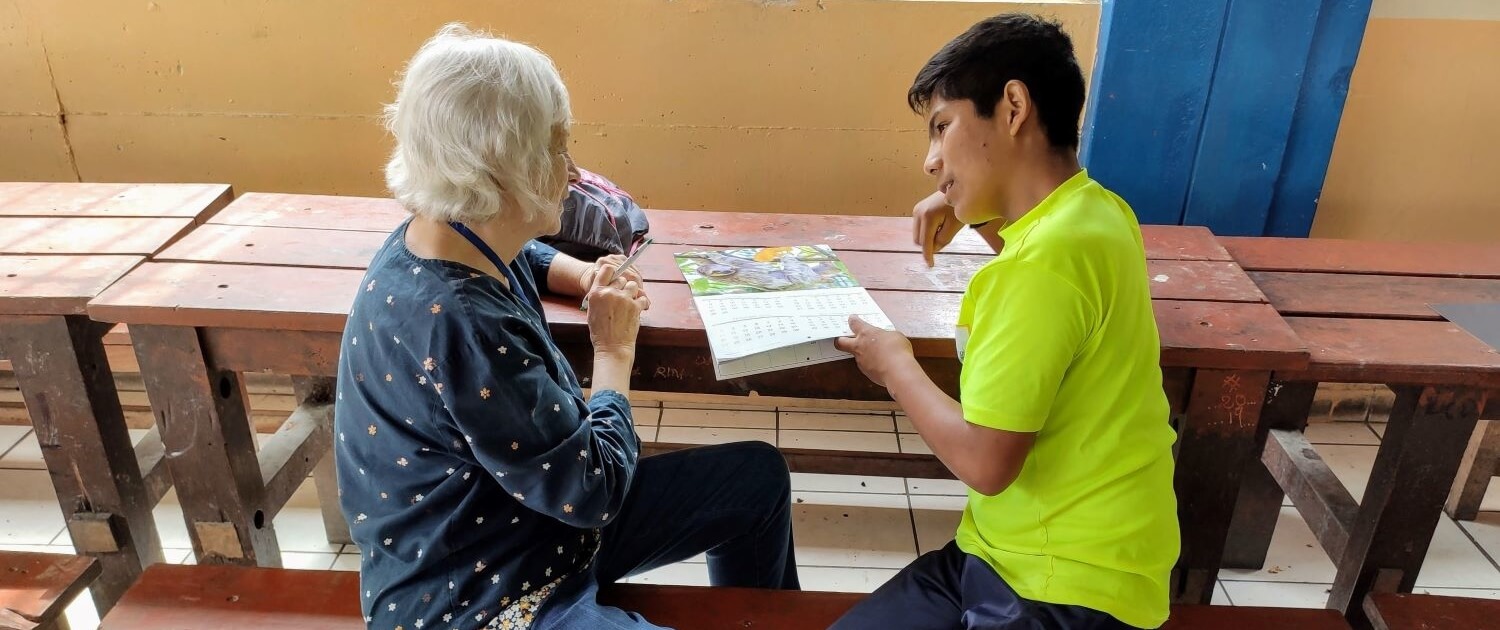 Volunteer teaching English to boy in Peru.