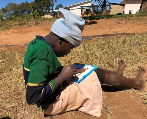 Boy works on homework in rural Tanzania.
