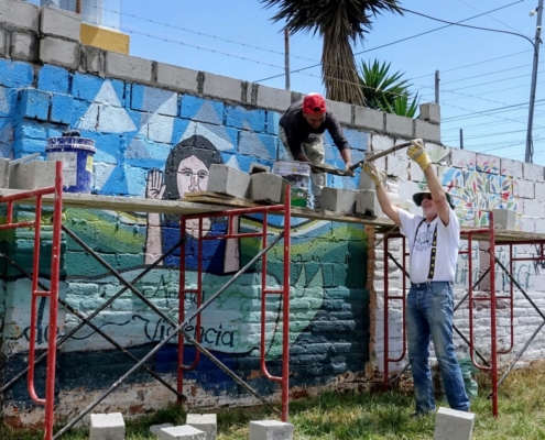Volunteer helps a local worker build a wall on an early childhood development center in Calderón, Ecuador.