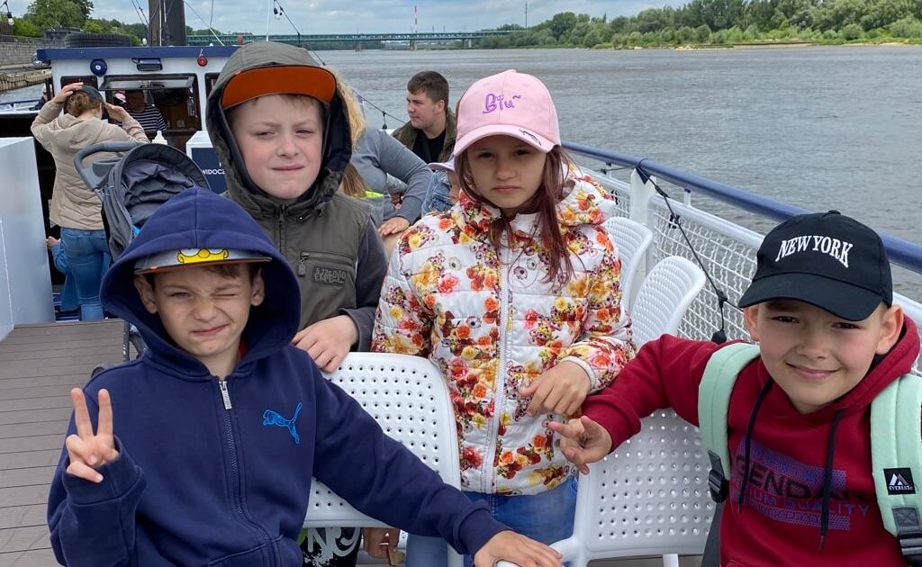 Four Ukrainian refugees in Poland on a field trip with volunteers.