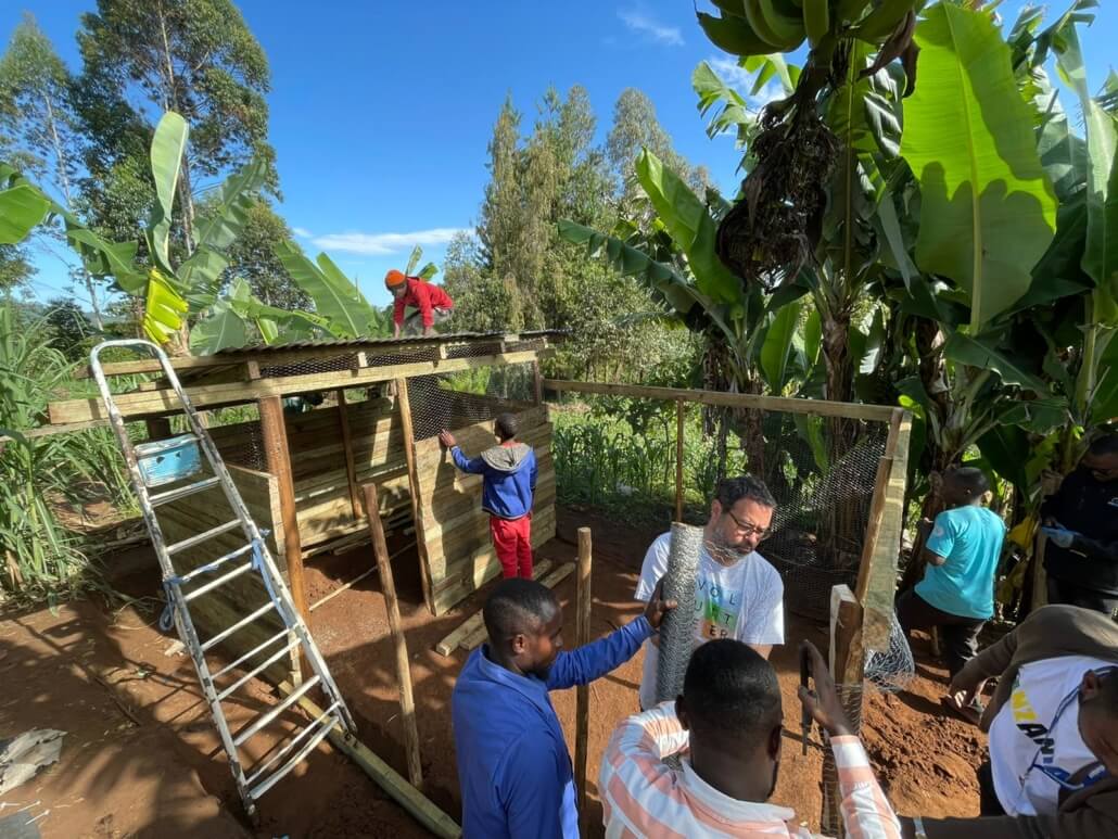 Global Volunteers staff, volunteers & community members build the chicken coops