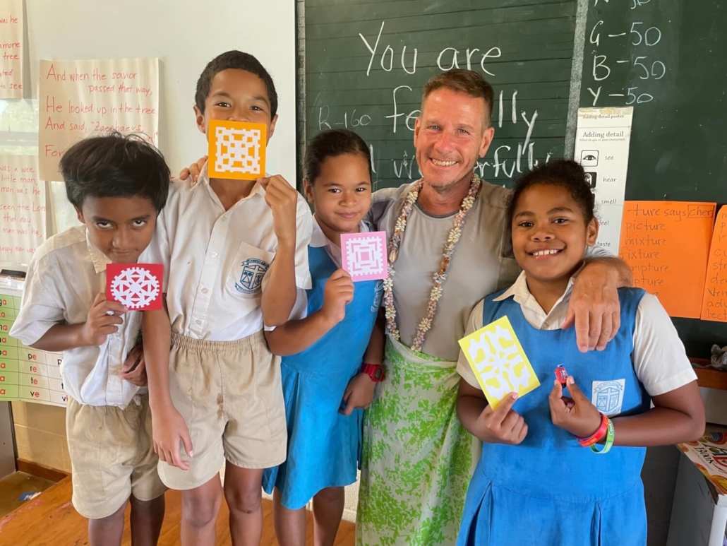 Martin Norman with a few of the students at st Josephs school posing with their snow flakes that he taught them about. (2)
