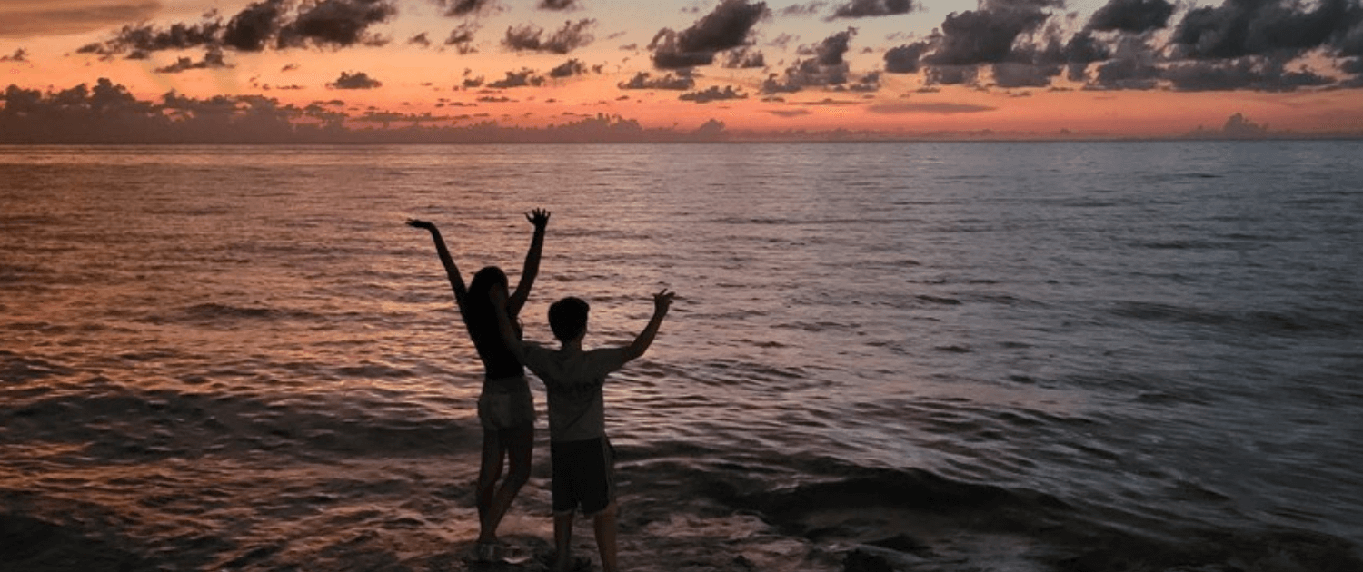 Mother and son take in the sunset while looking over the ocean in Cuba