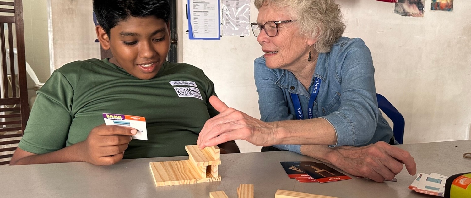 MAL2601A1 Marcia Potvin teaching a game to a young boy at Villa Paulos