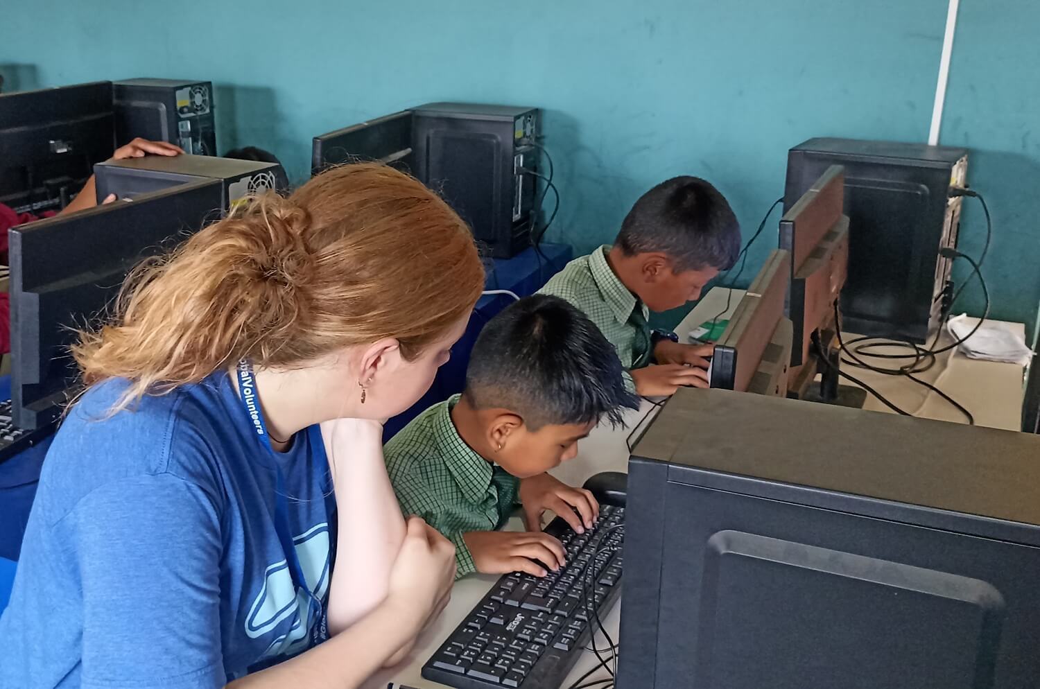 Volunteer teaching students in Nepal computer skills